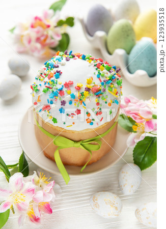 Delicious easter cakes decorated with colorful sprinkles and eggs on white table Delicious easter cakes decorated with colorful sprinkles and eggs on white table 123935518