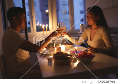 Couple toasting with wine glasses during romantic candlelit dinner 123936799