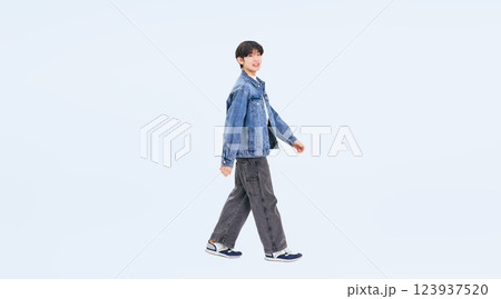 横向きに歩くカジュアルウェアの若い男性の全身写真 123937520