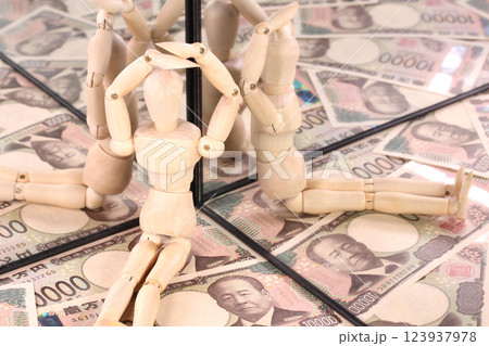 鏡に映る1万円札と木の人形 123937978