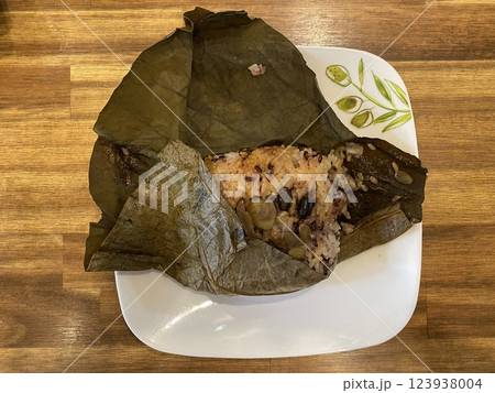 Mixed Grain Rice Wrapped in Lotus Leaf on a Plate Mixed Grain Rice Wrapped in Lotus Leaf on a Plate 123938004