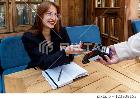 The girl pays the waiter using the phone The girl pays the waiter using the phone 123938155
