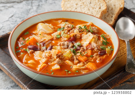 Yummy beef and cabbage soup with additional ingredients are tomato, kidney beans, carrot and celery closeup in the plate. Horizontal Yummy beef and cabbage soup with additional ingredients are tomato, kidney beans, carrot and celery closeup in the plate. Horizontal 123938802