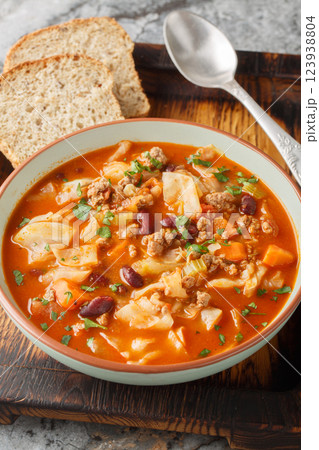 Ground beef cabbage soup, with red bean, onion, tomatoes, carrots and celery closeup in the plate. Vertical 123938804