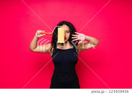 Happy young African woman with paintroller, toothy smile during home renovation 123939456