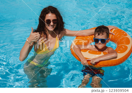 happy young mother and child boy son in swimming pool at a hotel on vacation at a resort in summer 123939504