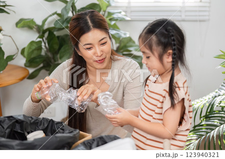 Sustainability and Family Involvement. A mother and daughter engage in eco-friendly recycling practices. 123940321