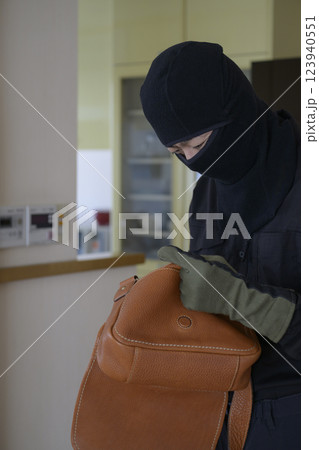 カバンの中を漁る強盗のイメージ 123940551