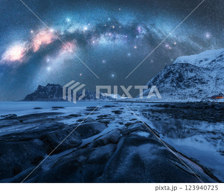 Night starry sky with Milky Way, rocky shore with stones in water. 123940725