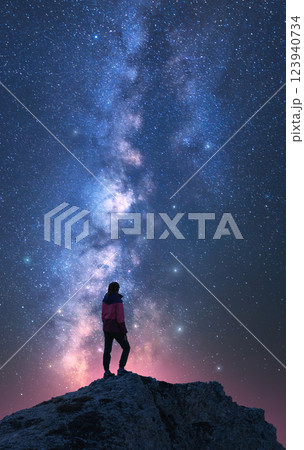 Milky Way and woman on mountain peak at starry night. Vertical 123940734