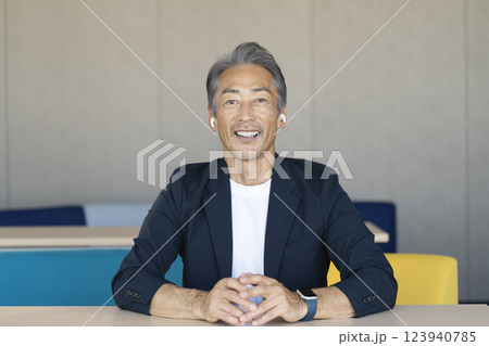 カメラ目線で話すイヤホンをした笑顔の60代の男性 123940785
