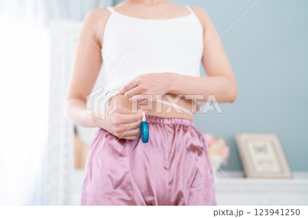 腹囲を図る若い女性　顔無し 123941250