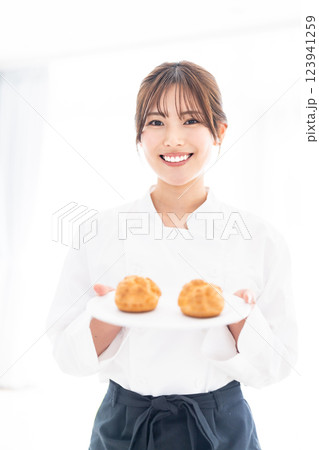 シュークリームの前に微笑む若いパティシエ 123941259