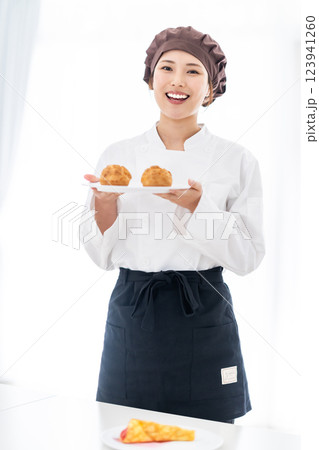シュークリームの前に微笑む若いパティシエ 123941260