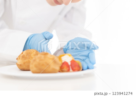 お皿にスイーツを並べるパティシエ　顔無し 123941274