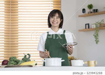 家事代行業者イメージ　料理をする30代の女性　カメラ目線で笑顔のポートレート 123941288