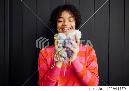 Close-up of a smiling African woman with balls of multicolored yarn. Close-up of a smiling African woman with balls of multicolored yarn. 123943579