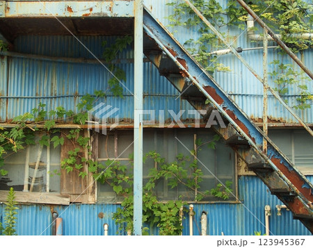 取り壊し予定の青い波型トタン壁のある廃屋のアパート風景 取り壊し予定の青い波型トタン壁のある廃屋のアパート風景 123945367