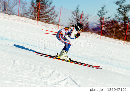 woman skier down snow-covered slope marked during competitive alpine skiing 123947192