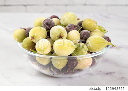 Frozen gooseberry berries in glass dish on a light background. healthy vegetarian dish. dietary product. 123948725