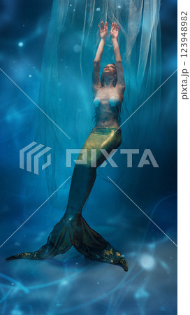 Graceful, elegant young woman, mermaid surrounded by delicate veils, floating in a dreamlike atmosphere 123948982