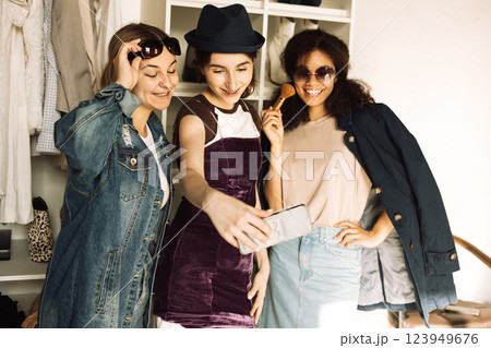 Charismatic teenage girls of different races collect clothes for the wardrobe Charismatic teenage girls of different races collect clothes for the wardrobe 123949676
