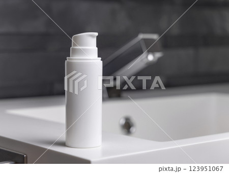 White one pump bottle near modern faucet on basin in dark grey bathroom close up, cosmetic mockup White one pump bottle near modern faucet on basin in dark grey bathroom close up, cosmetic mockup 123951067