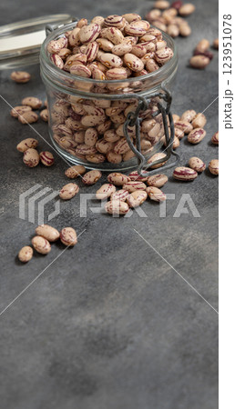 Glass jar full of dried pinto beans on gray closeup, copy space. Traditional Latin American legumes Glass jar full of dried pinto beans on gray closeup, copy space. Traditional Latin American legumes 123951078