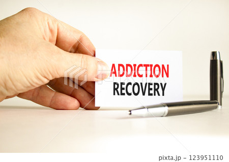 Addiction recovery symbol. Concept words Addiction recovery on beautiful white card. Psychologist hand. Beautiful white paper background. Psychology addiction recovery concept. Copy space. 123951110