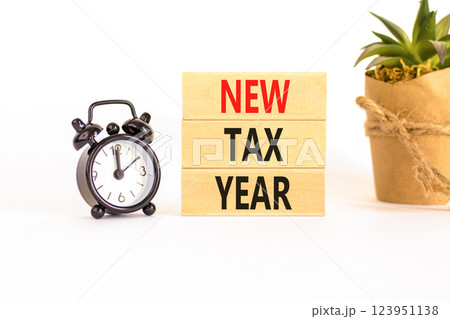 New tax year symbol. Concept words New tax year on beautiful wooden blocks. Beautiful white background. Black alarm clock. Business new tax year concept. Copy space. New tax year symbol. Concept words New tax year on beautiful wooden blocks. Beautiful white background. Black alarm clock. Business new tax year concept. Copy space. 123951138