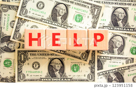 Help symbol. Concept word Help on beautiful wooden blocks. Dollar bills. Beautiful background from dollar bills. Business, lifestyle, support and help concept. Copy space. 123951158