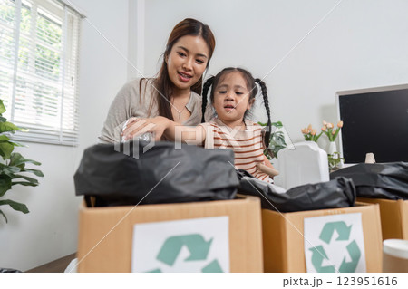 Family Bonding and Environmental Responsibility. A mother teaching her daughter about recycling. 123951616