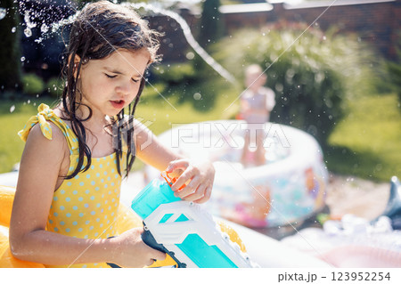 Joyful little girl in swimsuit with inflatable circle on terrace Joyful little girl in swimsuit with inflatable circle on terrace 123952254