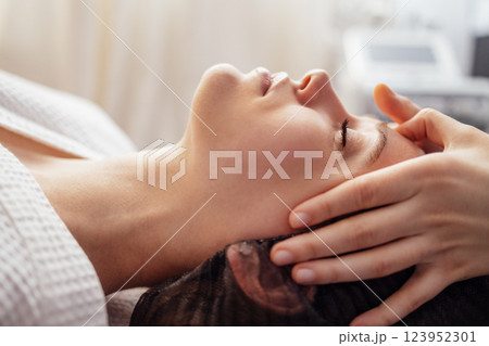 Brunette girl closed her eyes and enjoys a spa procedure in beauty salon Brunette girl closed her eyes and enjoys a spa procedure in beauty salon 123952301