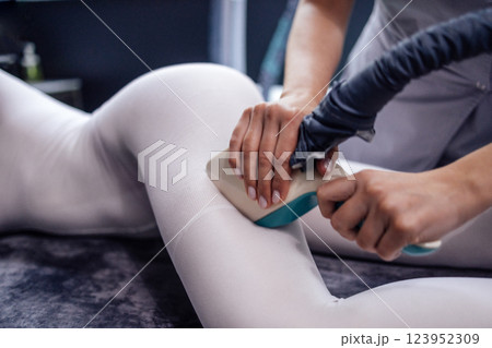 Cosmetician using LPG slimming apparatus on body of female client Cosmetician using LPG slimming apparatus on body of female client 123952309