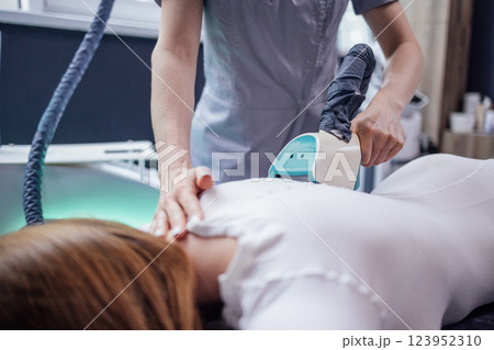 Cosmetician using LPG slimming apparatus on body of female client Cosmetician using LPG slimming apparatus on body of female client 123952310