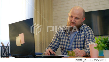 Remote professional freelancing, working on laptop at home workspace, sipping coffee with calm concentration, embodying modern digital nomad lifestyle. Concept of caffeine as doping 123953067