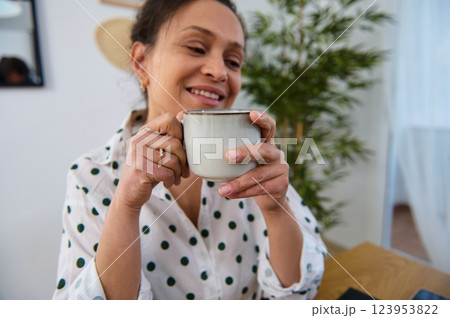 Happy Woman Working Remotely at Home Holding a Coffee Mug 123953822