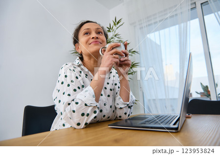 Young Woman Working Remotely in Cozy Home Office Environment Young Woman Working Remotely in Cozy Home Office Environment 123953824