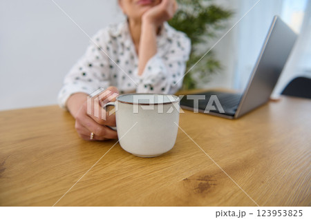 Cozy Remote Work Setting Featuring Laptop and Coffee Mug on Wooden Table 123953825