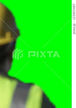 Blurred Back of Construction Worker Wearing Hard Hat and Safety Vest for Composites on Green Screen. 123955487