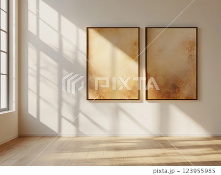 Empty frames hang on a wall above a decorative wooden floor, casting shadows. 123955985