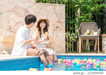旅行先のリゾートホテルのプールサイドで遊ぶカップル・夫婦 旅行先のリゾートホテルのプールサイドで遊ぶカップル・夫婦 123956930