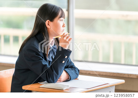 授業中に外を眺める中学生の女子生徒(進路・夢・思春期) 授業中に外を眺める中学生の女子生徒(進路・夢・思春期) 123958057