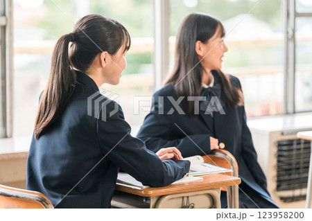 学校の教室で会話する中学生の女子生徒 123958200