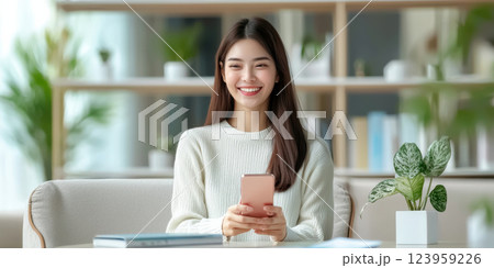 Smiling woman using smartphone in cozy indoor setting, surrounded by plants 123959226