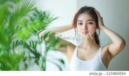 頭をマッサージしている若い女性とグリーンインテリア 123960084