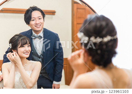 結婚式・披露宴の支度をする笑顔の新郎新婦（ブライダルジュエリー・アクセサリー） 123961103