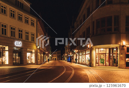 night view of quiet european street with tram tracks illuminated by warm lights and storefronts during winter. High quality photo 123961670