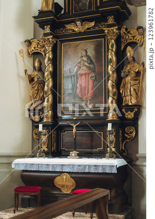 Scenic view of a charming lakeside village featuring a historic church, surrounded by majestic mountains. Tourists enjoy the tranquil atmosphere and beautiful architecture in Konigsse lake Bavaria 123961782